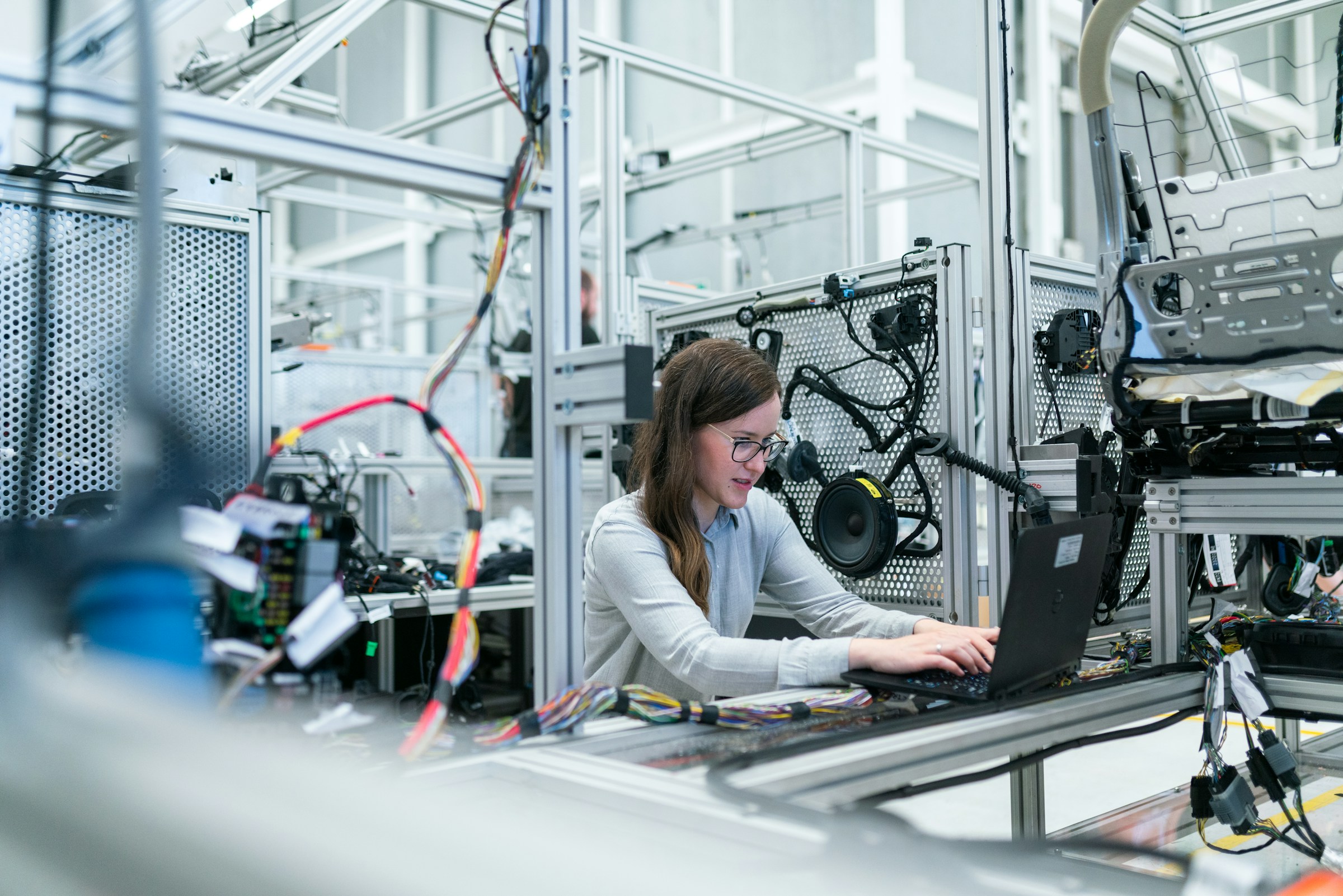 Engineers collaborating beside production machinery on a modern factory floor